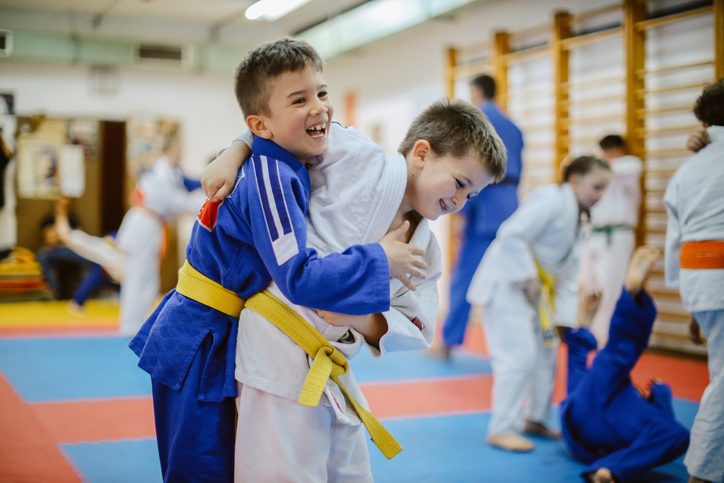 9 - 14 year old kids training judo with their sensei teacher at the dojo gym training ground.